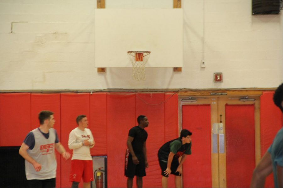 Four boys wait for drill to start during boys varsity basketball tryouts.