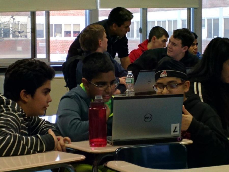 7th graders Ali Bashir, Harris Agha, and Sukhsimran Singh work on laptop to start stock market game